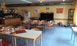 Gemeinschaftsraum mit gedeckten Tischen und Küche | © Caritas München und Oberbayern